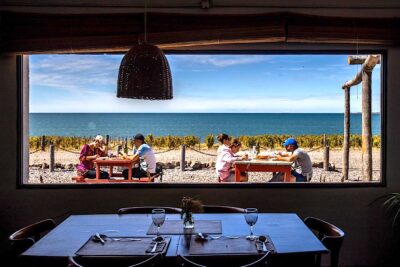 Un comedor al aire libre, otro interior, las vides y el mar. Foto, Leandro Vesco.