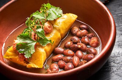 Tamal de maíz pelado con conejo, hongos y hierbas. Jennifer Rodríguez en Mestizo