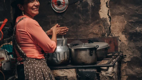 La imagen ilustra el tema del reportaje, la cocina campesina de Boyacá, con una mujer en una cocina humilde